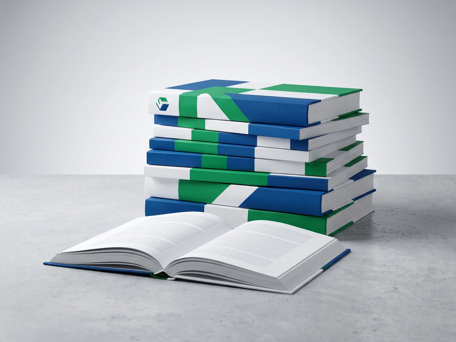 A stack of hardcover and softcover books with blue, green and white covers, and an open book in front.