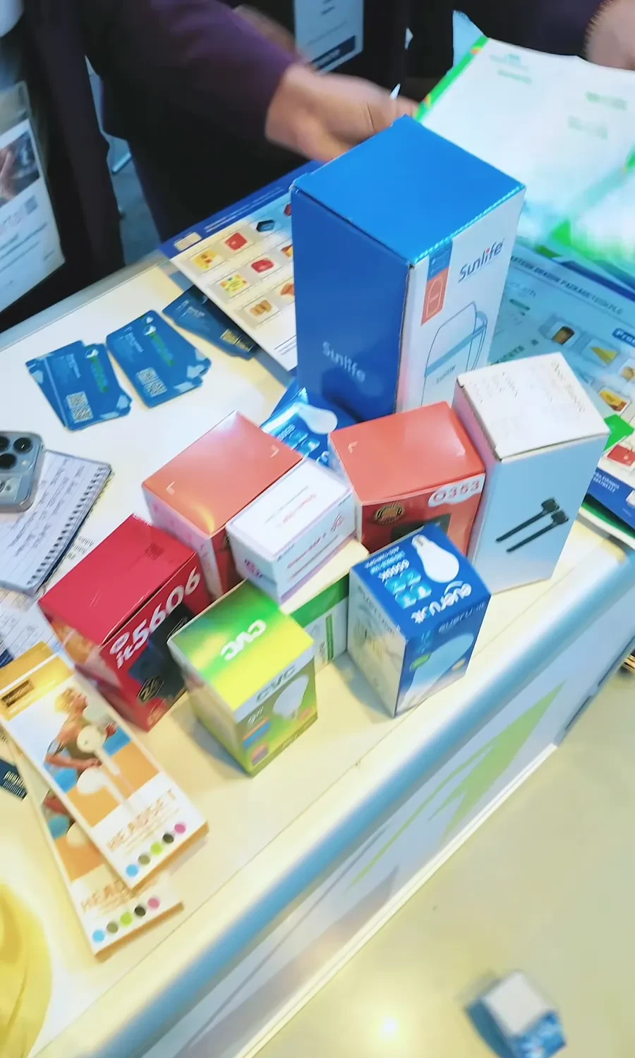Printed cartons, labels and packing tape are arranged on the exhibition table.