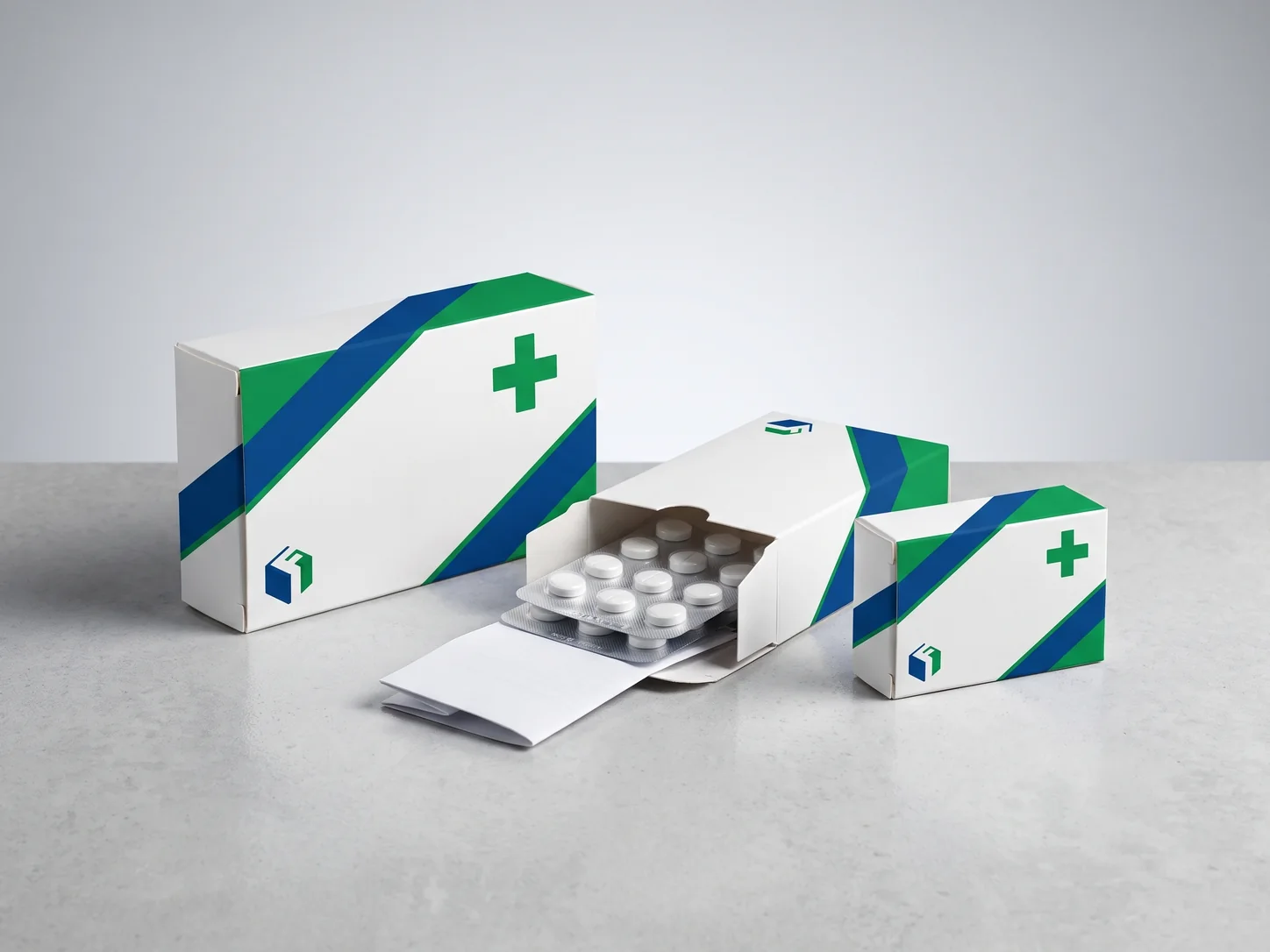 Three white medicine cartons printed with blue bands and a green plus sign, one open with a blister pack and a folded leaflet.