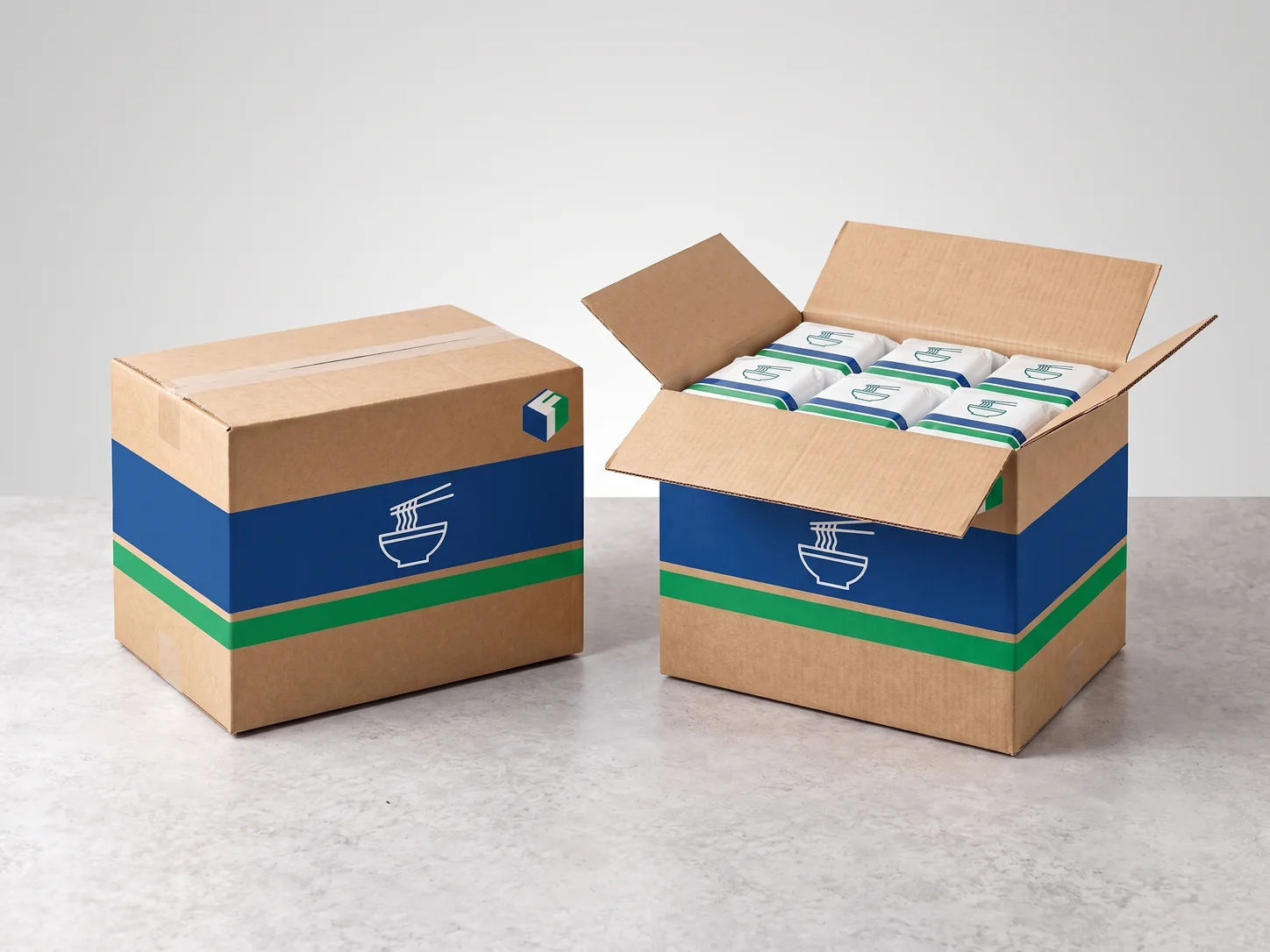 Brown corrugated noodle cartons printed with blue and green bands and a noodle bowl symbol, one open and full of noodle packs.