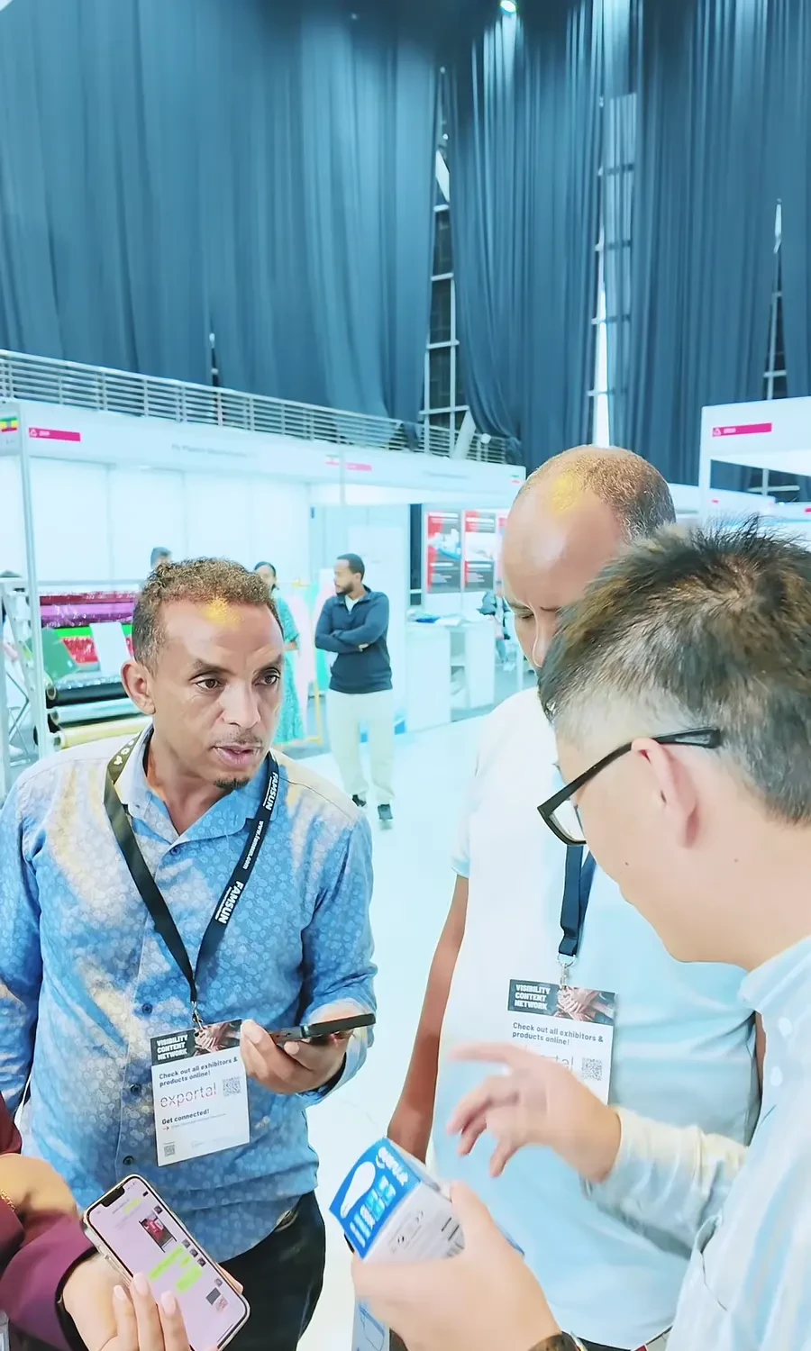 A trade-show visitor holds and inspects a printed box sample.